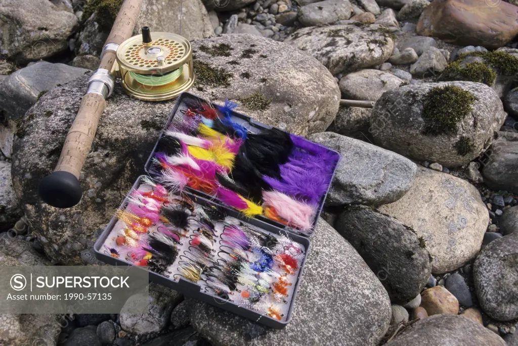 Flyfishing: Spey rod and flybox on rocks beside river, Canada.