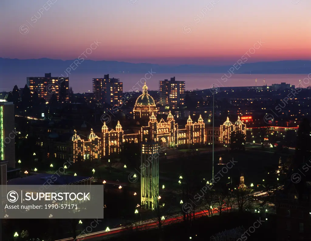 Parliament buildings lit up at night, shot from above with James Bay and Olympic mountains beyond, Victoria, Vancouver Island, British Columbia, Canad...