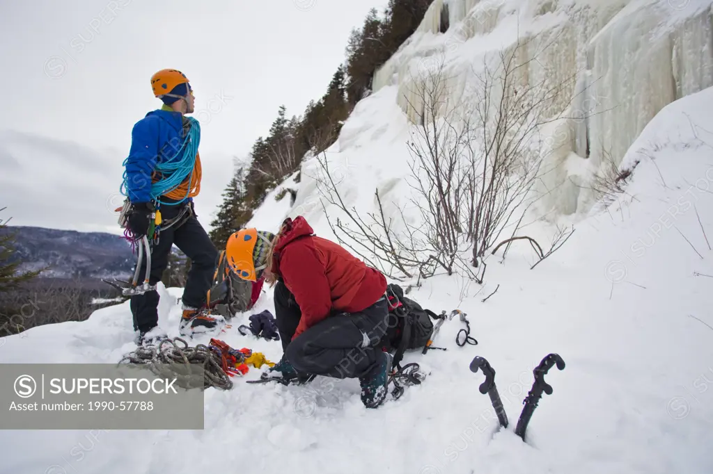 A young man and woman get ready to climb, La Mer de Glace 4+, near St Raymond, Quebec, Canada