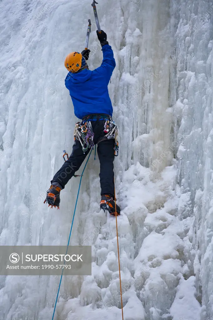 A young man climbs some steep ice, La Mer de Glace 4+, near St Raymond, Quebec, Canada