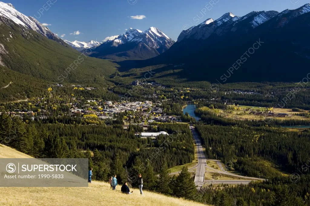 Visitors in meadow overlooking Banff townsite from Mt  Norquay, Banff National Park, Alberta, Canada
