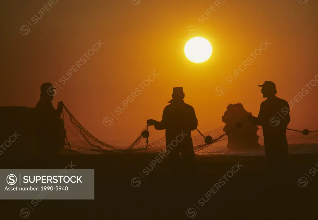 Gaspereau fishermen in sunset, Cousin´s Shore Beach, Prince Edward Island, Canada