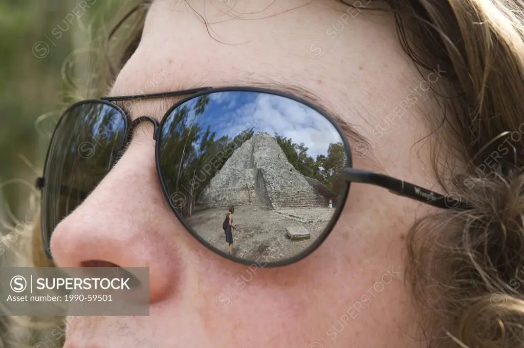 Reflection of Nohoch Mul pyramid in young mans glasses, Coba, Quintana Roo, Mexico