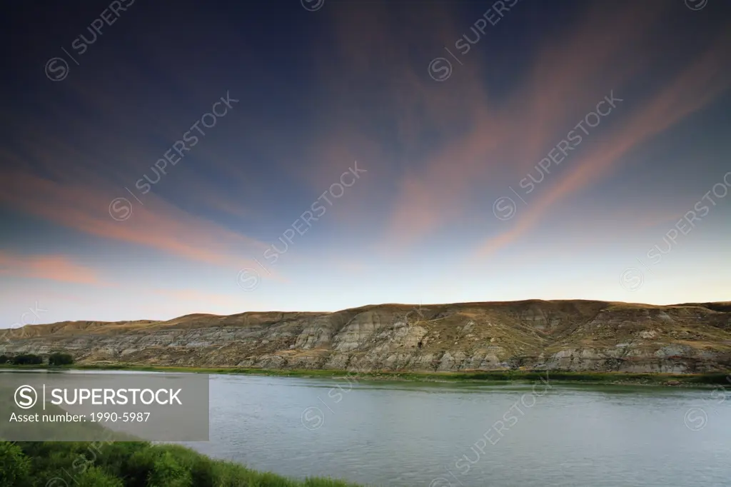 Pink clouds lit by the sunrise over the South Saskatchewan River and Valley north of Medicine Hat near Sandy Point Park west of the Alberta-Saskatchew...