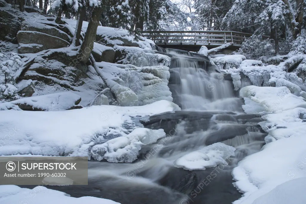 Little high falls and pedestrian bridge in winter near Bracebridge, Ontario