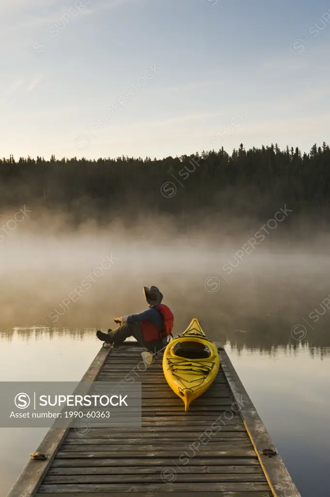 man on dock with kayak, Little Deer Lake, Lac La Ronge Provincial Park, Northern Saskatchewan, Canada