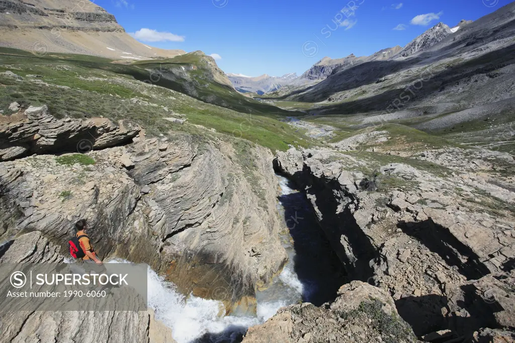 Hiker enjoying a spectacular view down the Dolomite Creek valley in the backcountry of Banff National Park in the Canadian Rockies, Alberta, Canada