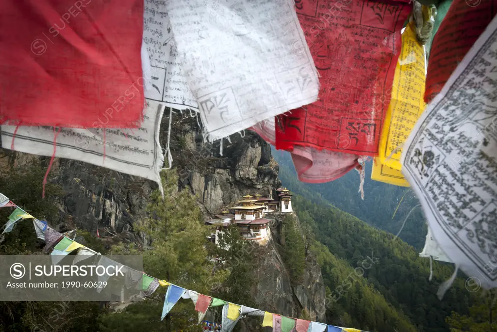 Taktsang Tigers Nest Monastery peeks out behind some prayer flags above Paro, Bhutan