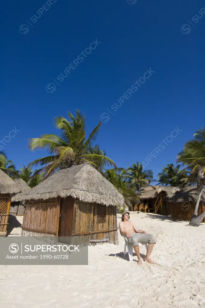 Yound man, Beach shacks and chairs, Tulum Beach, Quintana Roo, Mexico