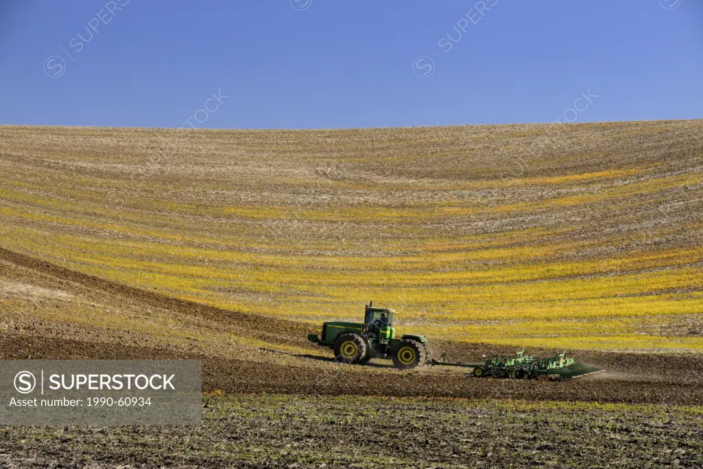 Tractor tilling Palouse farmland, Palouse, Washington, USA