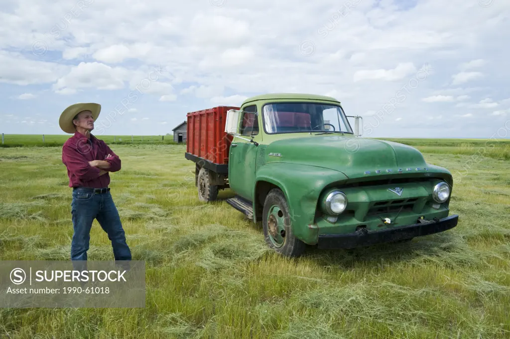 older man beside old farm truck, near Ponteix, Saskatchewan, Canada