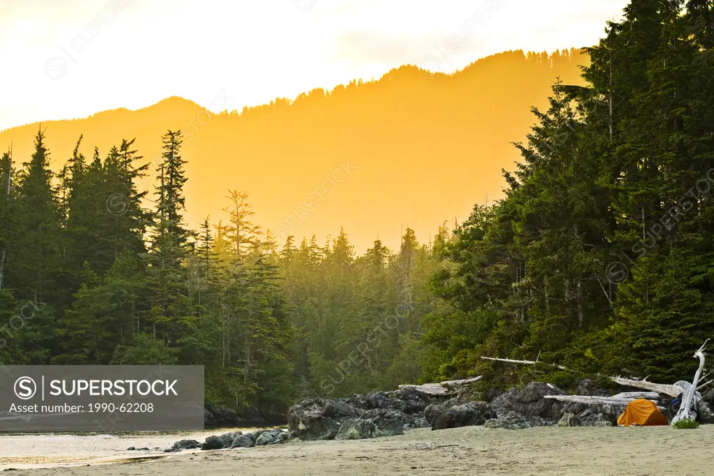 A hikers tent is setup on the beach at sunset on Flores Island north of Tofino. The Wildside Trail begins in the village of Ahousaht and runs 11km alo...
