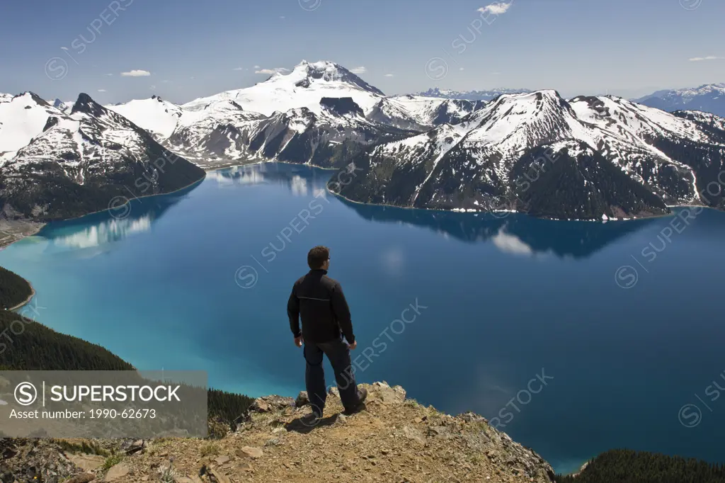 Hiker on top of Panorama Ridge over looking Garibaldi Lake in Garibaldi Provincial Park between the towns of Squamish and Whistler in British Columbia...