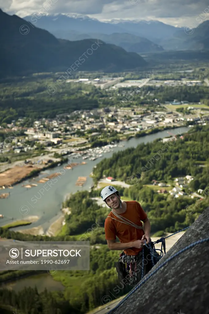 Trad Climber toping out Tantalus Wall, Stawamus Chief Provincial Park, Squamish, British Columbia Canada