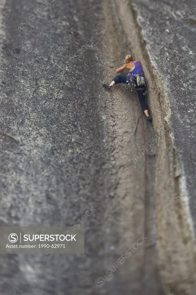 A strong female climber climbs a corner crack, Caboose 10b, Squamish, BC