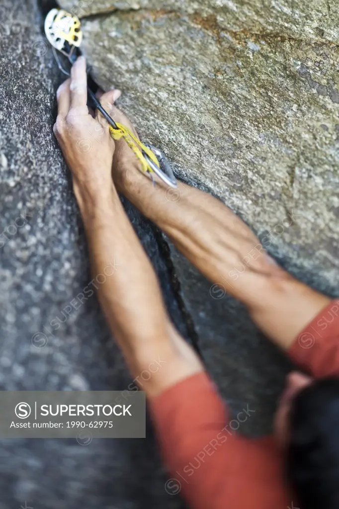 A strong male climber climbs a corner crack, Caboose 10b, Squamish, BC