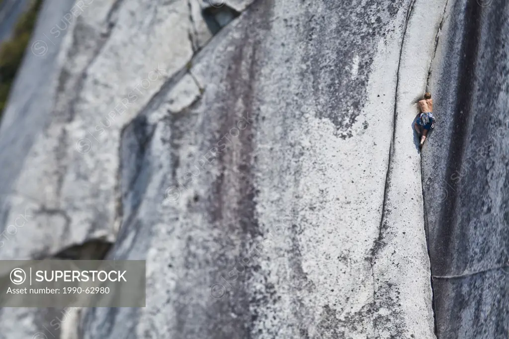 A strong male climber climbing Crescent Crack 10d, Squamish, BC