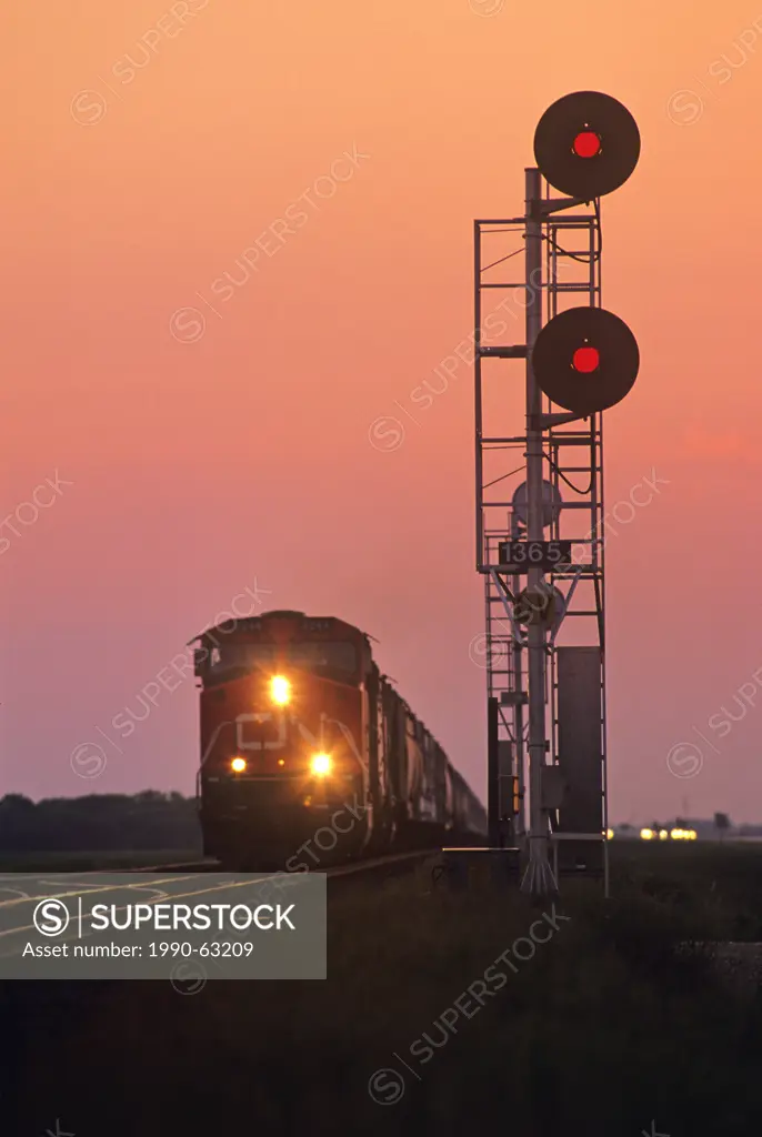 close up of rail signal with approaching train in the background, near Winnipeg, Manitoba, Canada