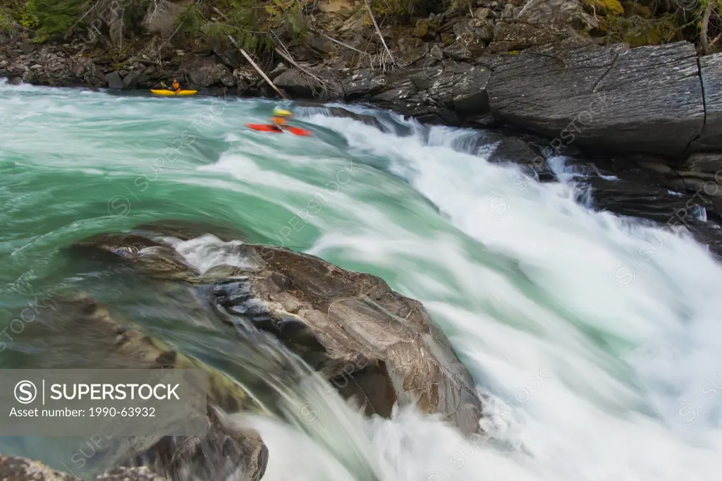 Two male kayakers drop into a big rapid on the Fraser River, Mt Robson Provincial Park, BC