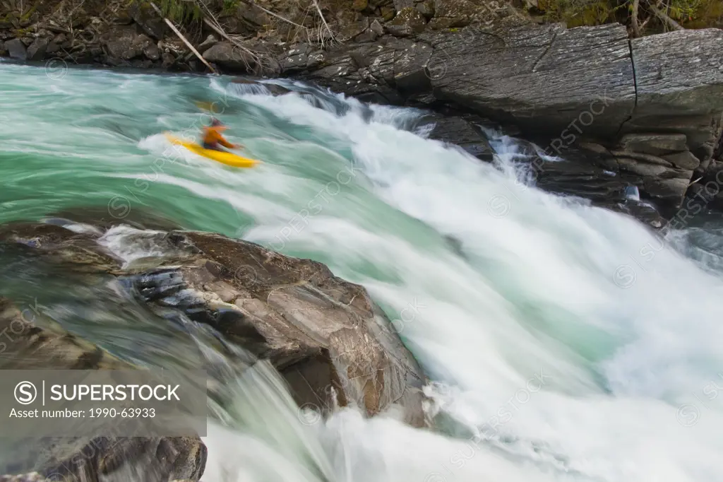 A male kayaker drops into a big rapid on the Fraser River, Mt Robson Provincial Park, BC
