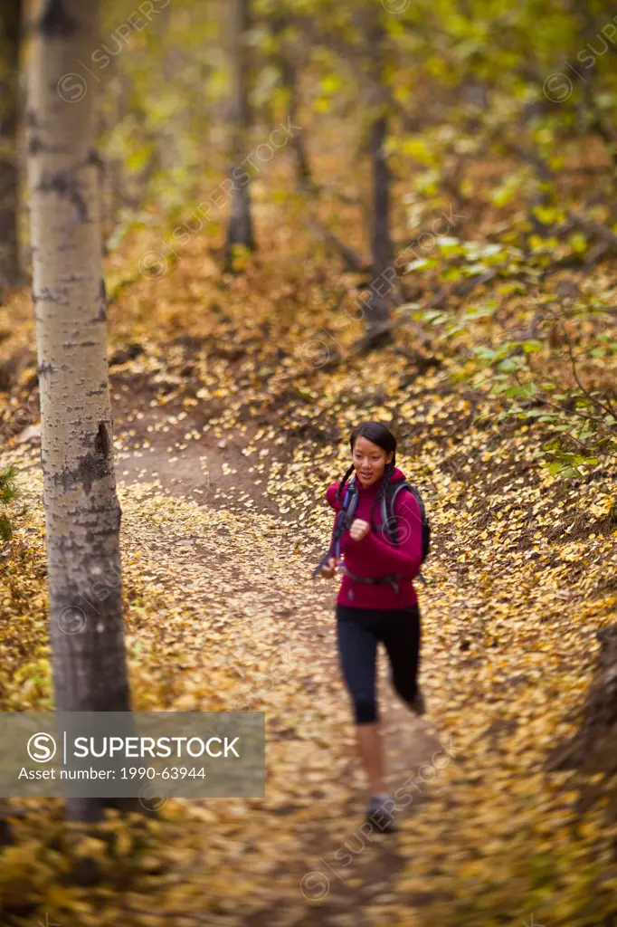A young, fit woman trail running the Highline trail in Canmore, AB