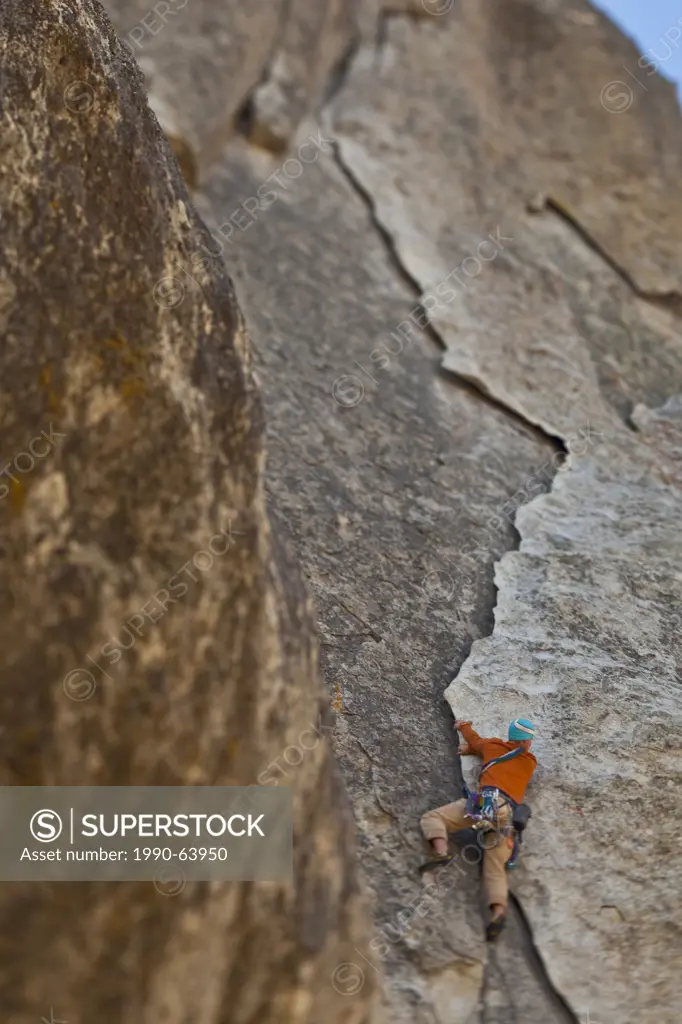 A male climber places protection and climbs Rye Crisp 5.8, City of Rocks, Idaho