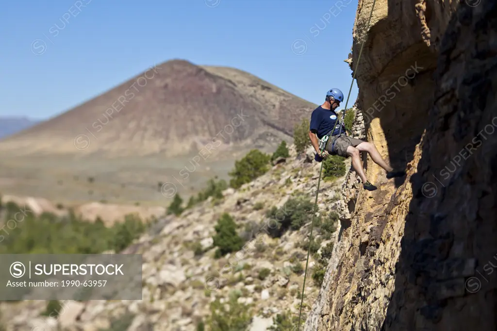 A man rappelling after rock climbing in St. George, Utah