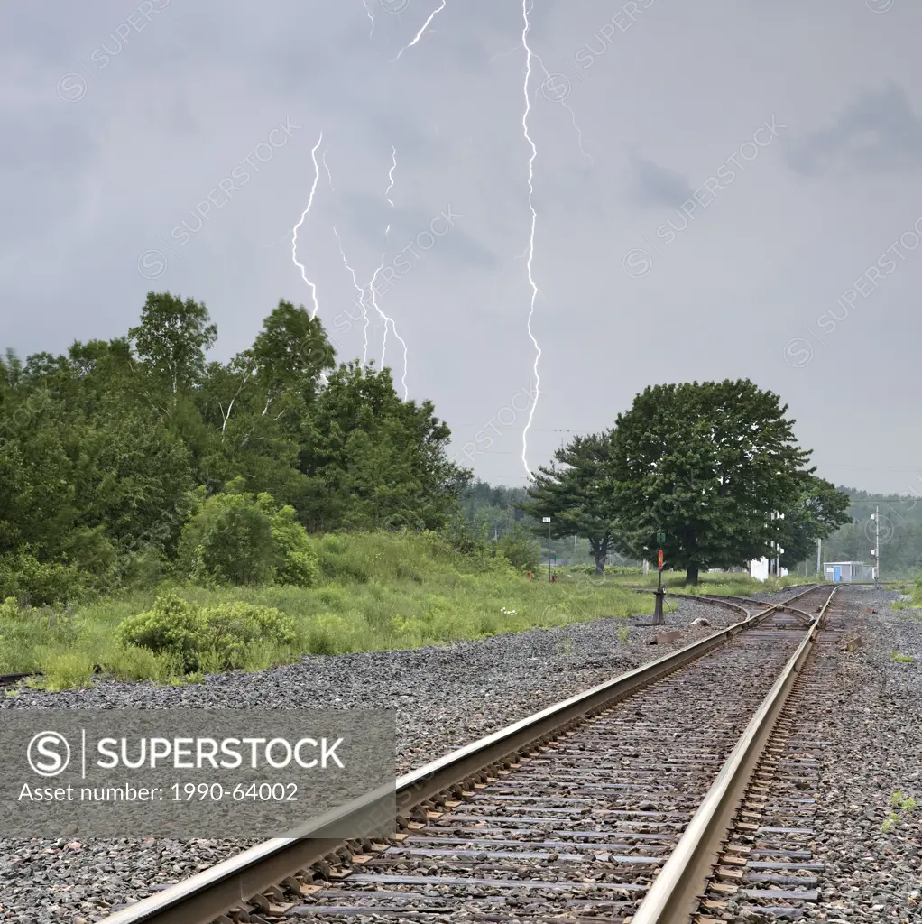 Multi_bolt cloud to ground lightning strike over railroad train tracks in Windsor Junction, Nova Scotia, as a summer storm moves through the area.