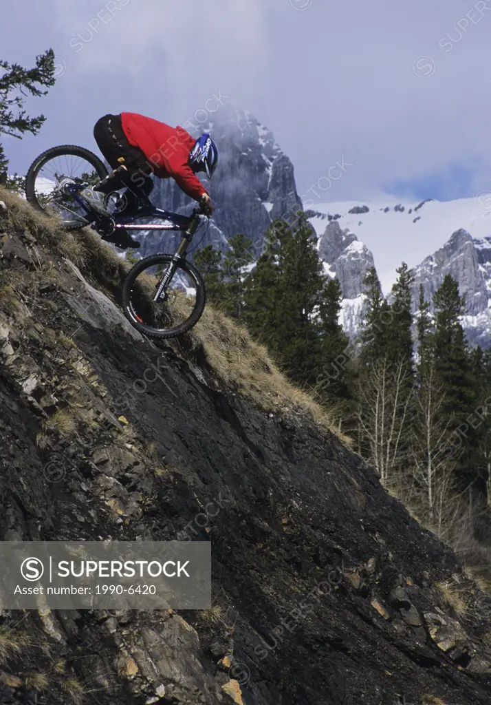 a male mountain biker riding down a steep descent in Canmore, Rocky Mountains, Canmore, Alberta, Canada