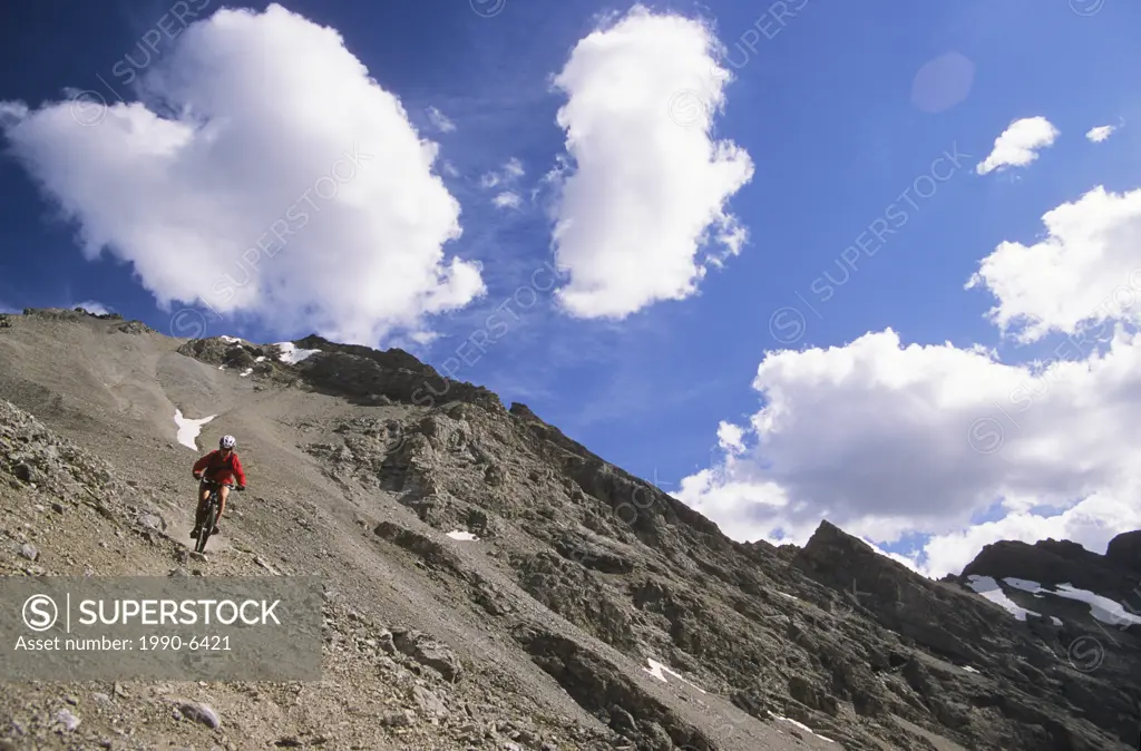 young female mountain biker riding down scree trail in Kananaskis Country, Rocky Mountains, Alberta, Canada