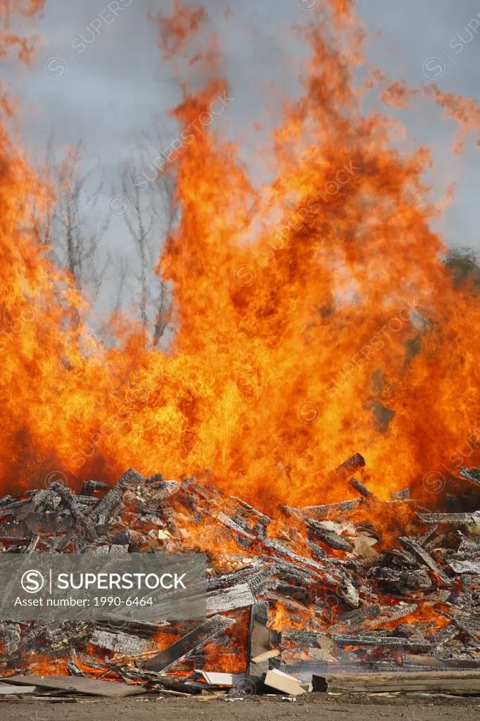 Wood waste pile being burned at Regional Transfer Station, Smithers, British Columbia, Canada