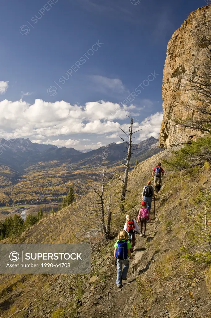 Young family hiking on Castle Mountain Trail in autumn, Fernie, BC, Canada.