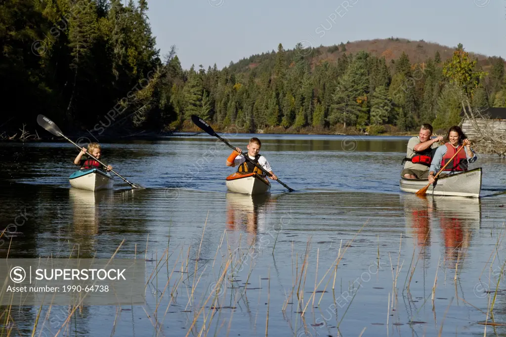 Family canoeing on Source Lake, Algonquin Park, Ontario, Canada.