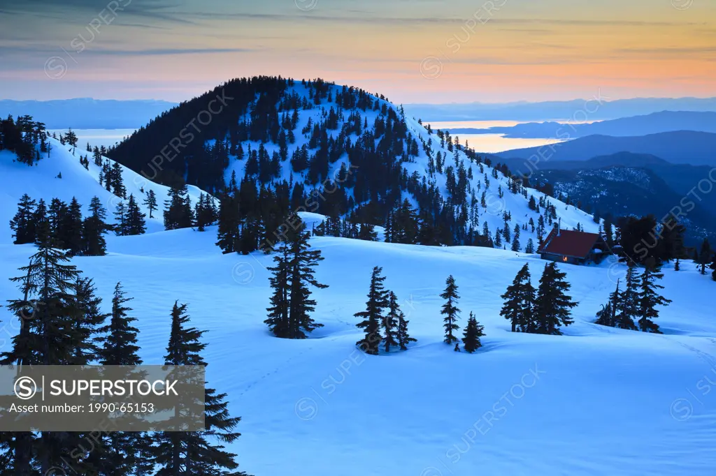 Dusk descends on Mt. Steele cabin in Tetrahedron Provincial park on the Sunshine Coast with the Strait of Georgia and Vancouver Island as backdrop, Br...