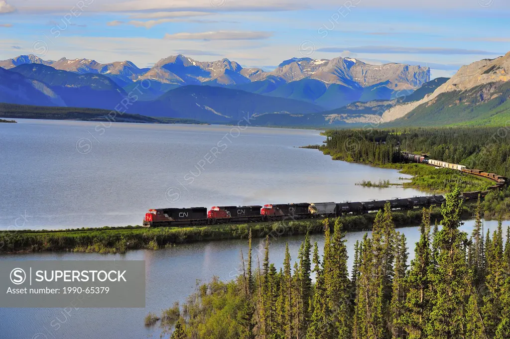 A Canadian National freight train traveling along Brule Lake in the foothills of the Rocky Mountains of Alberta Canada.
