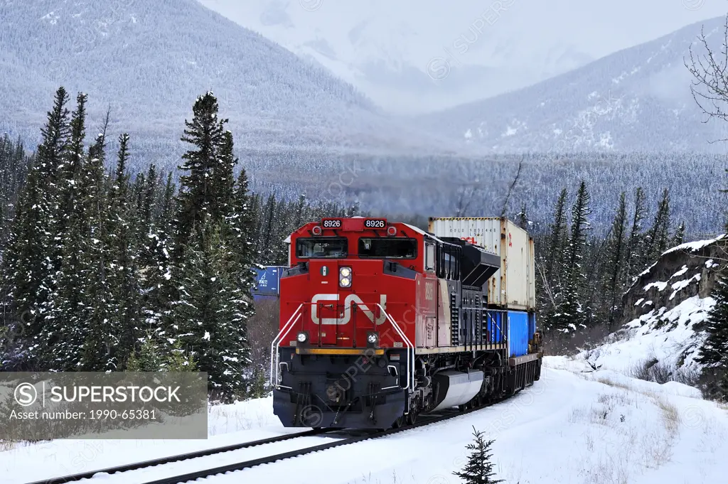 A Canadian National freight train pulling a load of containers on a snowy winters day near the hamlet of Brule in the rocky mountains of Alberta Canad...