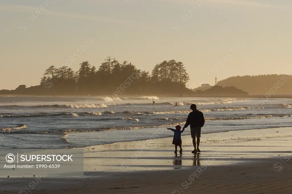 Father & daughter walk along beach, Chesterman Beach near Tofino, Vancouver Island, British Columbia, Canada