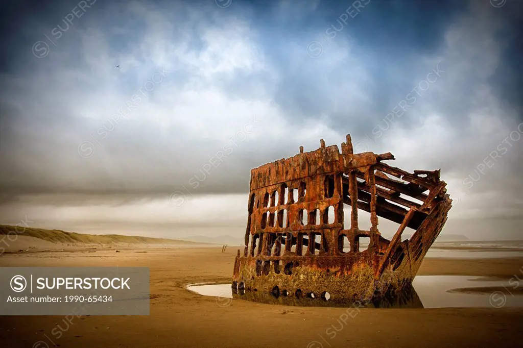 The wreck of the four_masted steel barque the Peter Iredale that ran ashore October 25, 1906, on the Oregon coast near Fort Stevens, Oregon, USA.