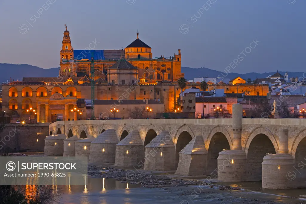 Puente Romano bridge spanning the Rio Guadalquivir river and the Mezquita Cathedral_Mosque during dusk in the City of Cordoba, UNESCO World Heritage S...