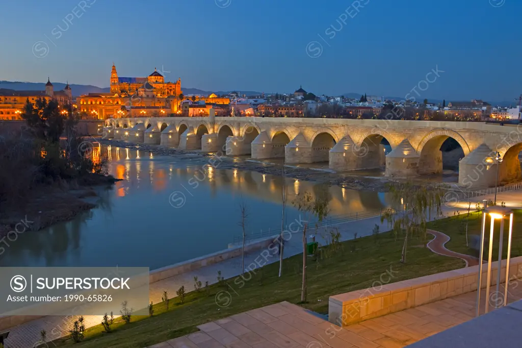 Puente Romano bridge spanning the Rio Guadalquivir river and the Mezquita Cathedral_Mosque during dusk in the City of Cordoba, UNESCO World Heritage S...