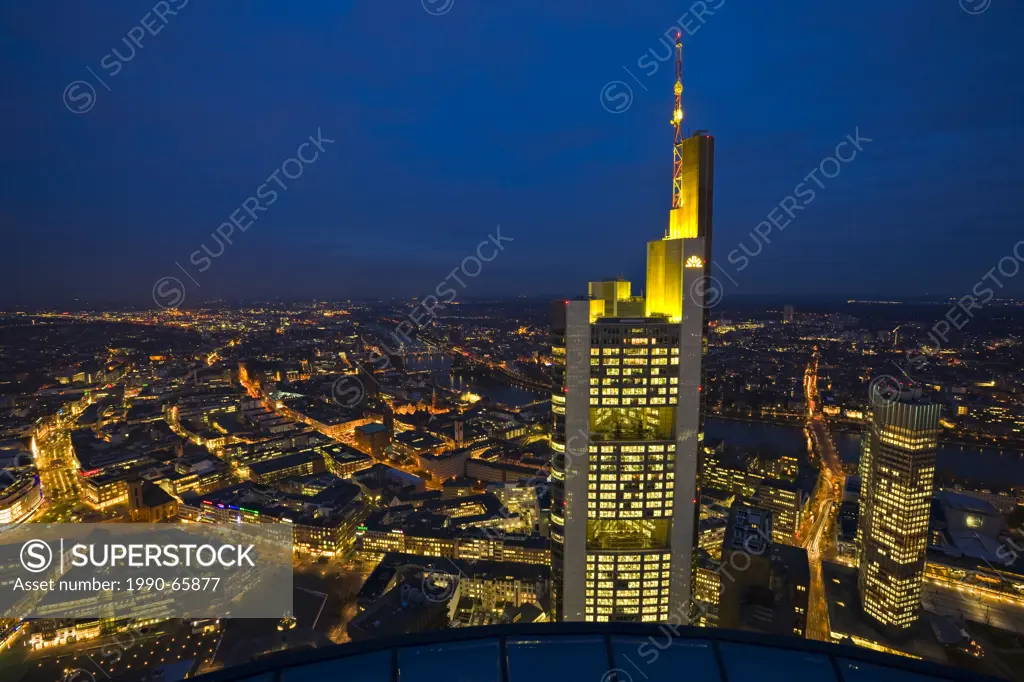 Commerzbank Tower illuminated with yellow lights at dusk as seen from the Main Tower in the City of Frankfurt am Main, Hessen, Germany, Europe.