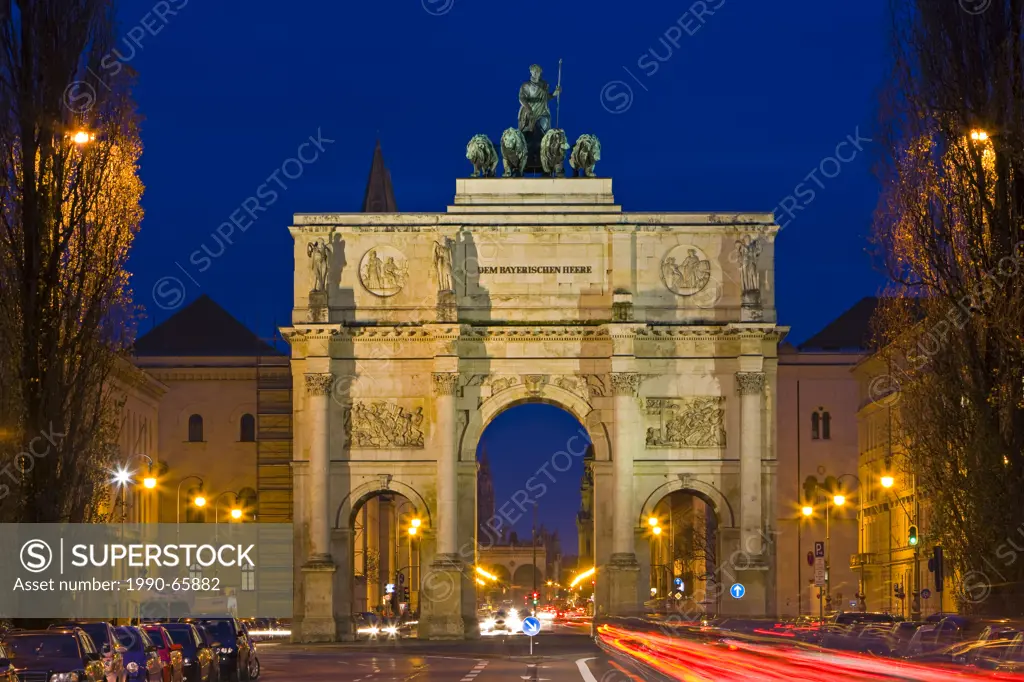 The Siegestor Victory Gate with traffic flowing around it at dusk in the Schwabing district in the City of München Munich, Bavaria, Germany, Europe.