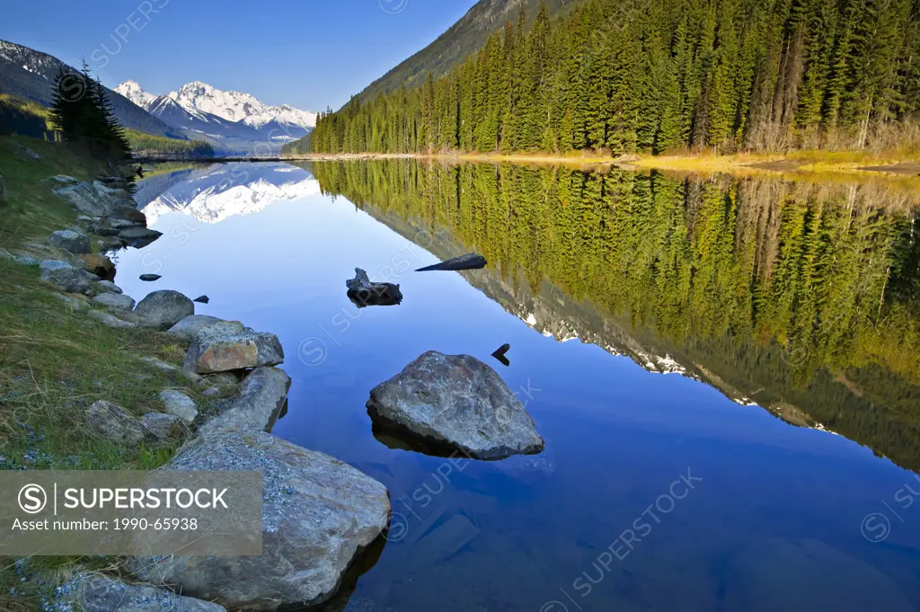 Reflections of snow capped mountains in Duffy Lake, British Columbia, Canada.