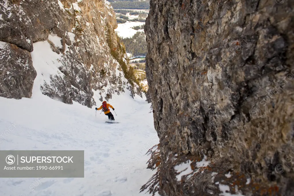 A male backcountry skier rips down a steep coulior close to downtown Banff. Mt. Cory, Banff National Park, AB