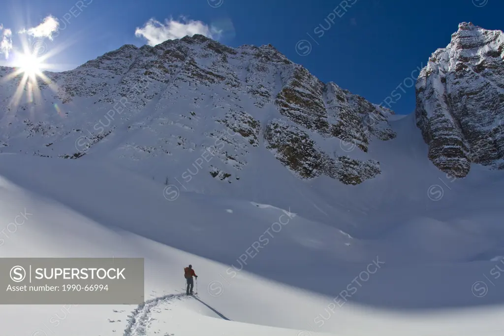 A male backcountry skier skins toward Mt. Bell, Banff National Park, AB