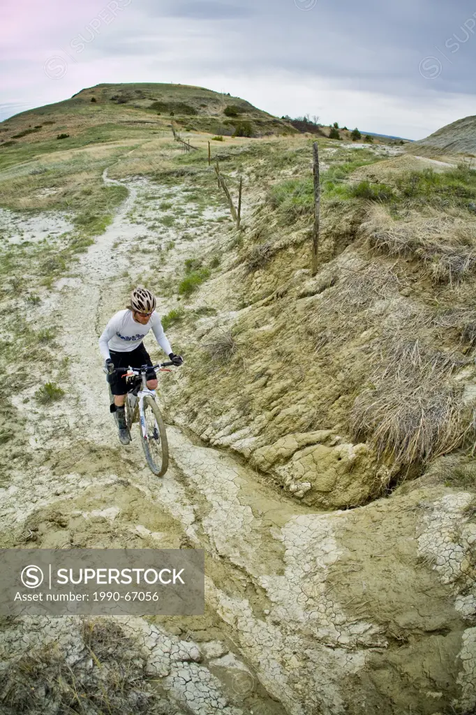A male mountain biker enjoys a muddy section of the Maah Daah Hey Trail, North Dakota