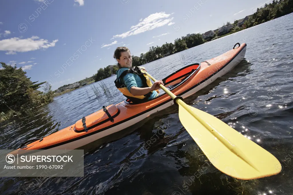 Woman kayaking on Lake Micmac in Dartmouth, Nova Scotia, part of Halifax Regional Municipality.