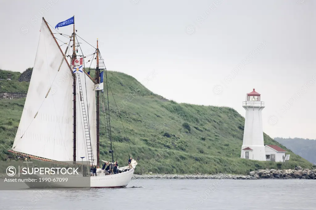 Tall ship Bowdoin sails past the lighthouse on George´s Island in Halifax Harbour during the Parade of Sail conclusion to the 2007 Tall Ships festival...