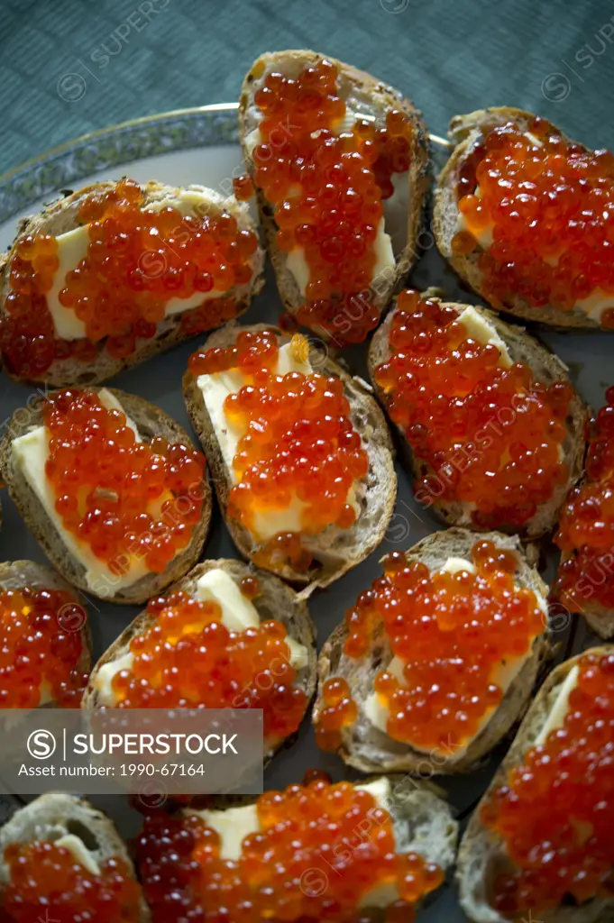 Red caviar sandwiches placed in a plate on a table