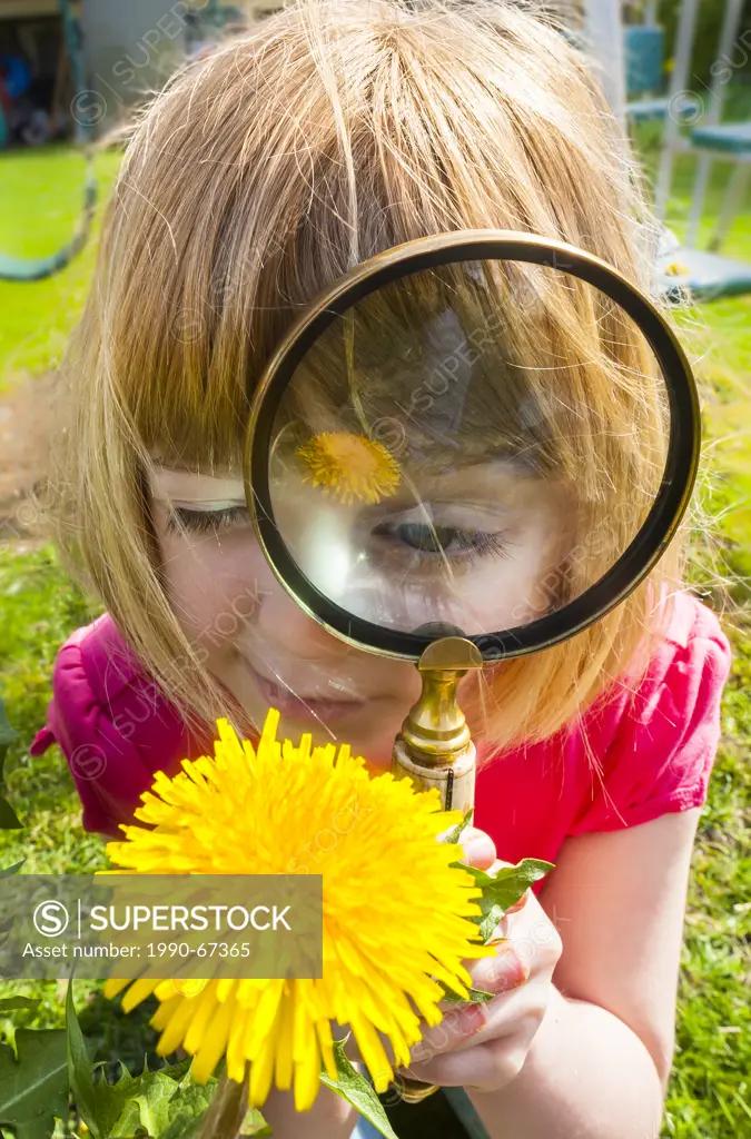 Girl using magnifying glass.